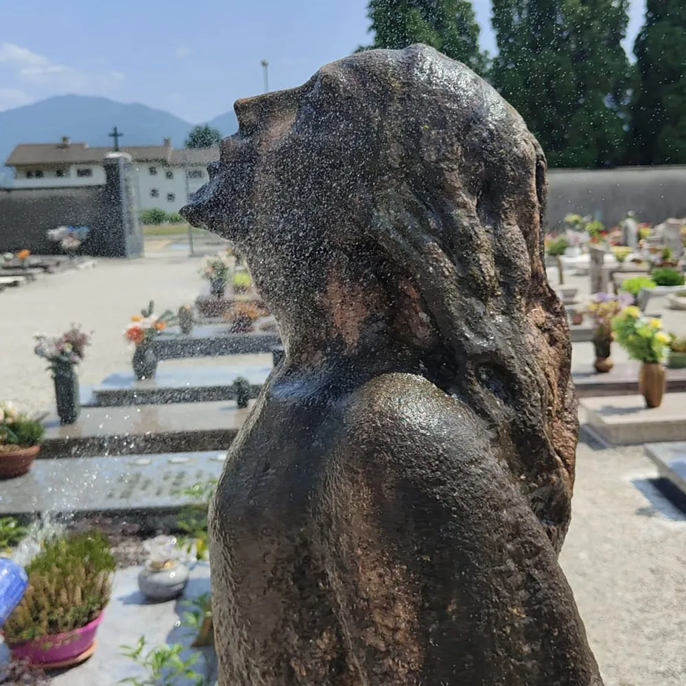 Dettaglio del volto e della spalla della statua investiti dagli spruzzi durante la pulitura
